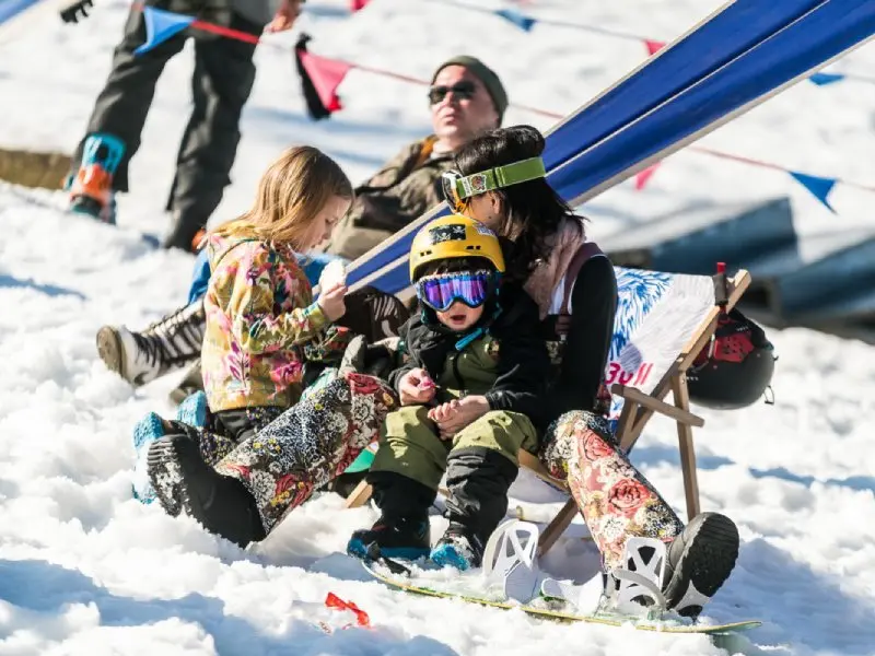 Family with children relaxing on sun loungers in a winter atmosphere