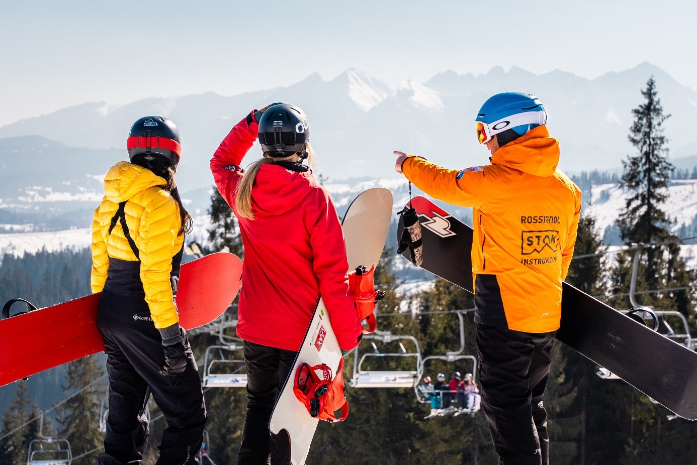 Instruktor Szkoły STOK z dwiema snowboardzistkami – planują trasę na Kotelnicy Białczańskiej